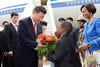 President Jinping is handed flowers by Dzunani Manzini from the Thatchfield Curro School, Waterkloof Air Force Base, Pretoria, South Africa, 2 December 2015.