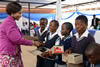 Minister Maite Nkoana-Mashabane hands over shoes to Motlatso Mohlasedi (11) at the Mamahlo Primary School, Nobody-KaMothiba Village, Limpopo, South Africa, 5 February 2016.