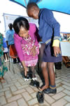 Minister Maite Nkoana-Mashabane hands over shoes to Bonolo Mmatli, a Grade 3 scholar (9), at Makanye Primary School-Ga-Makanye Village, Limpopo, South Africa, 5 February 2016.